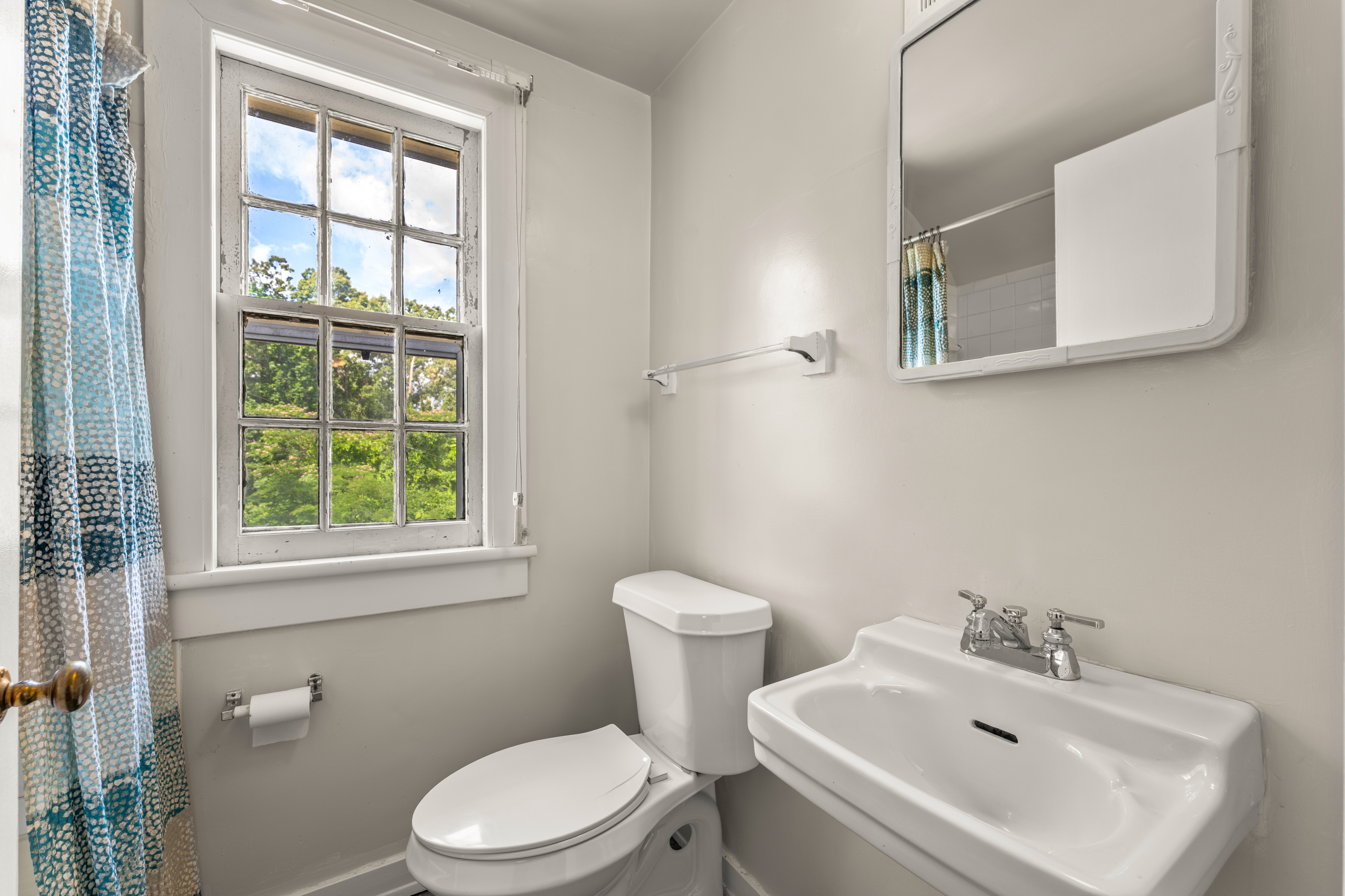 The apartment bath — sash window and paneled shower