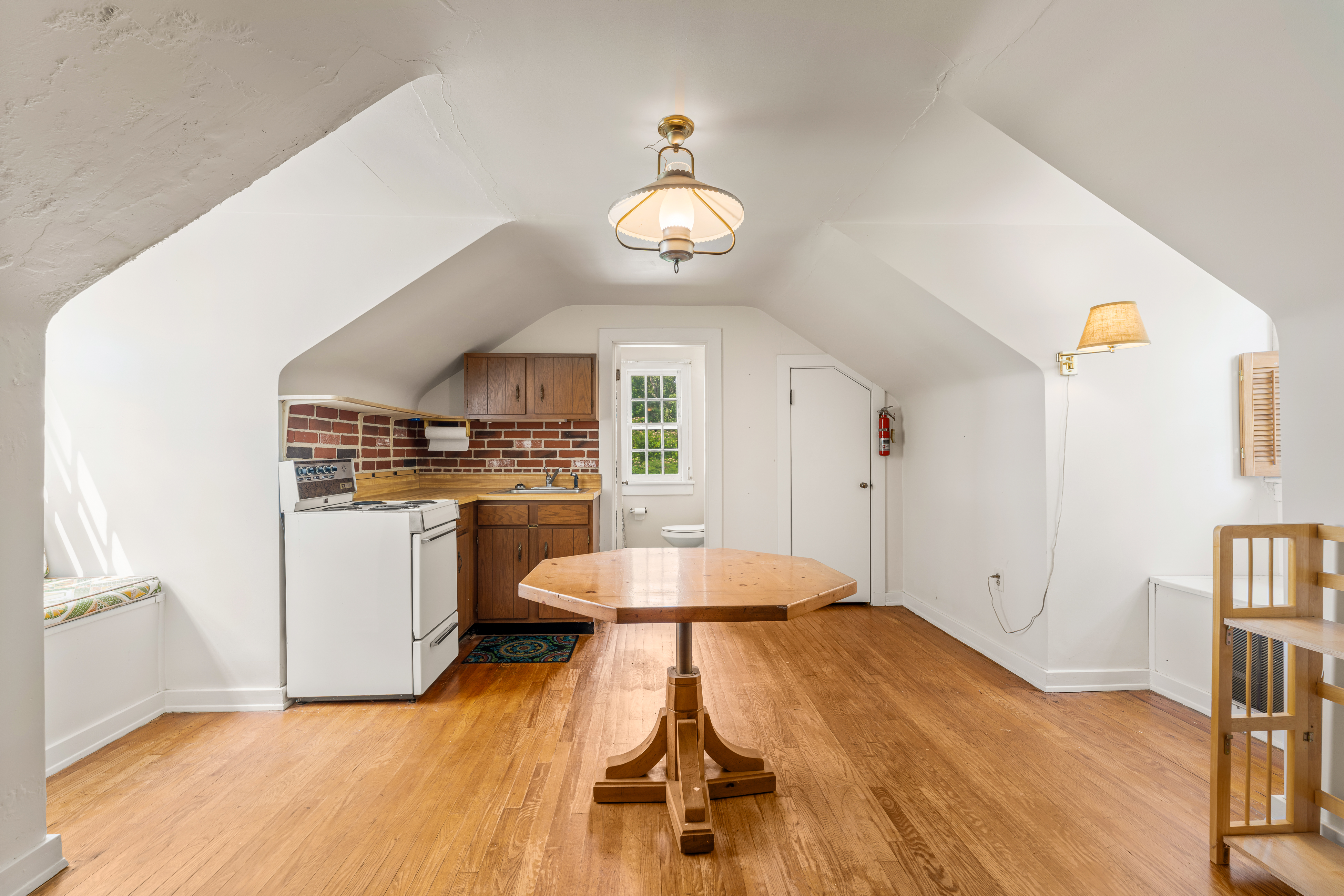 The carriage-house apartment — kitchen and dining beneath dormers