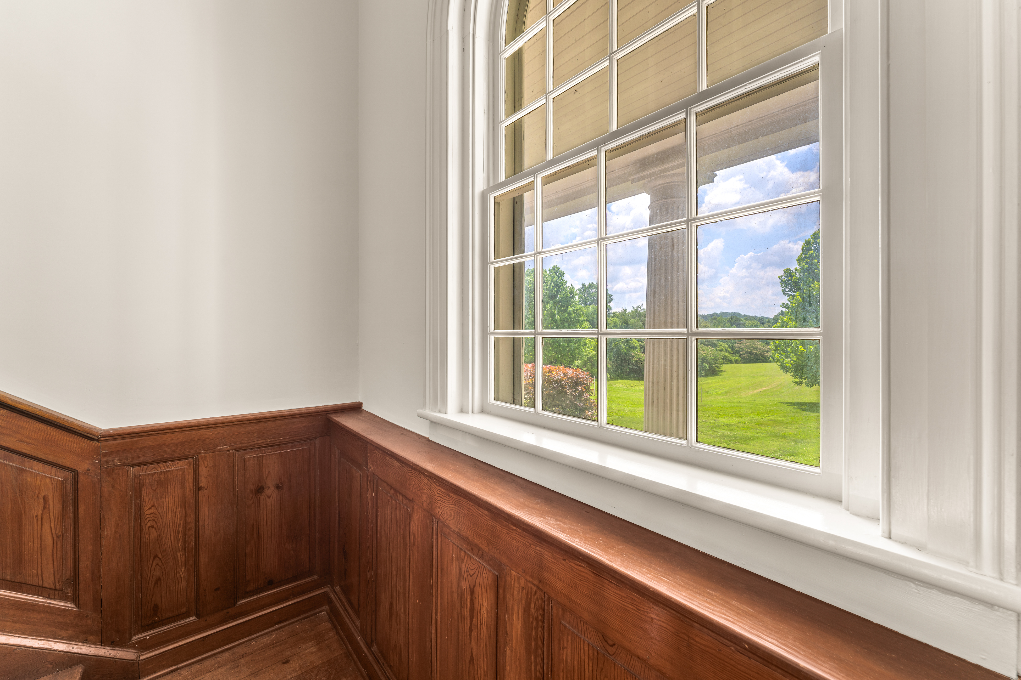 A wainscoted passage with meadow-view sash
