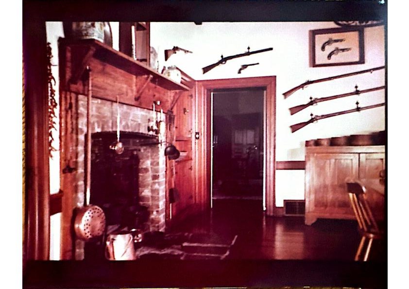 The gun room — collected long arms at the fireplace