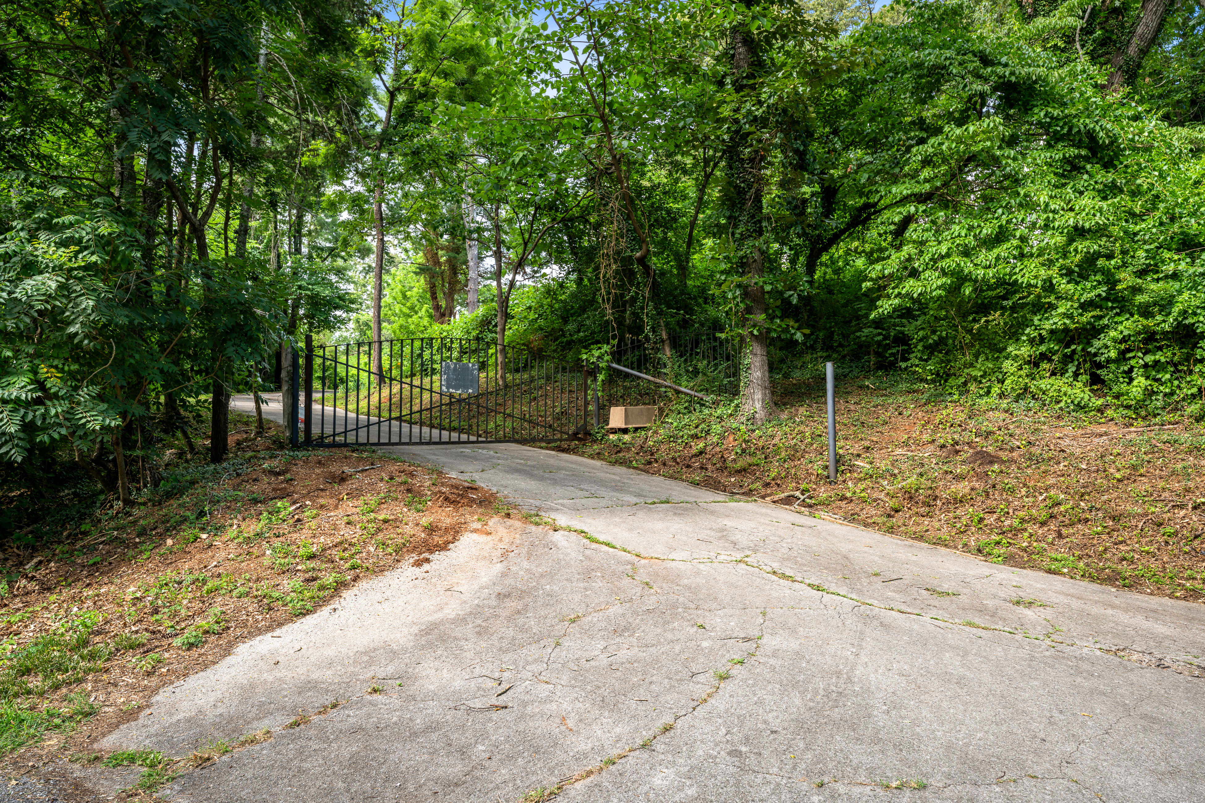 The gated drive through the wooded edge