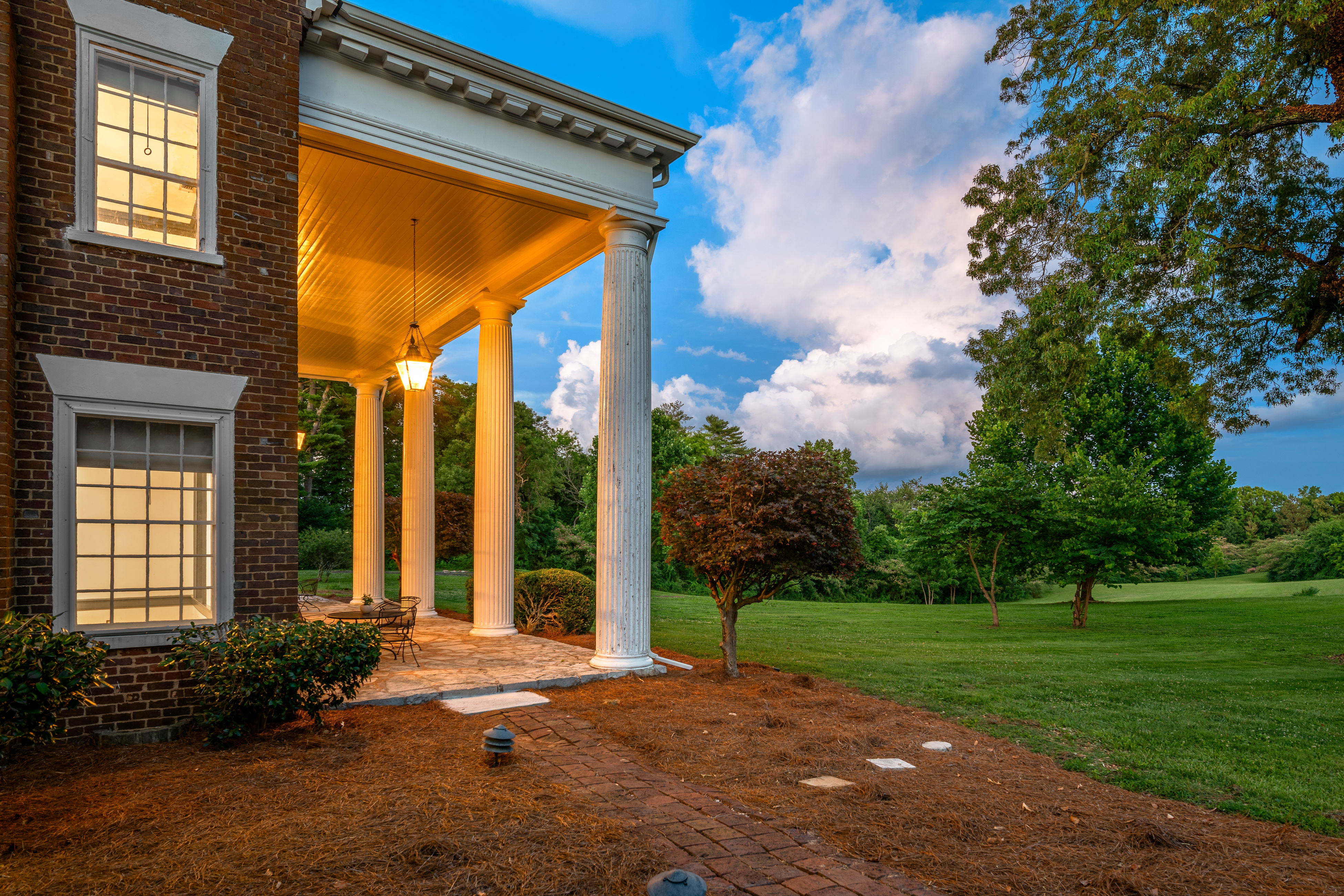 The side porch at dusk with lit interiors
