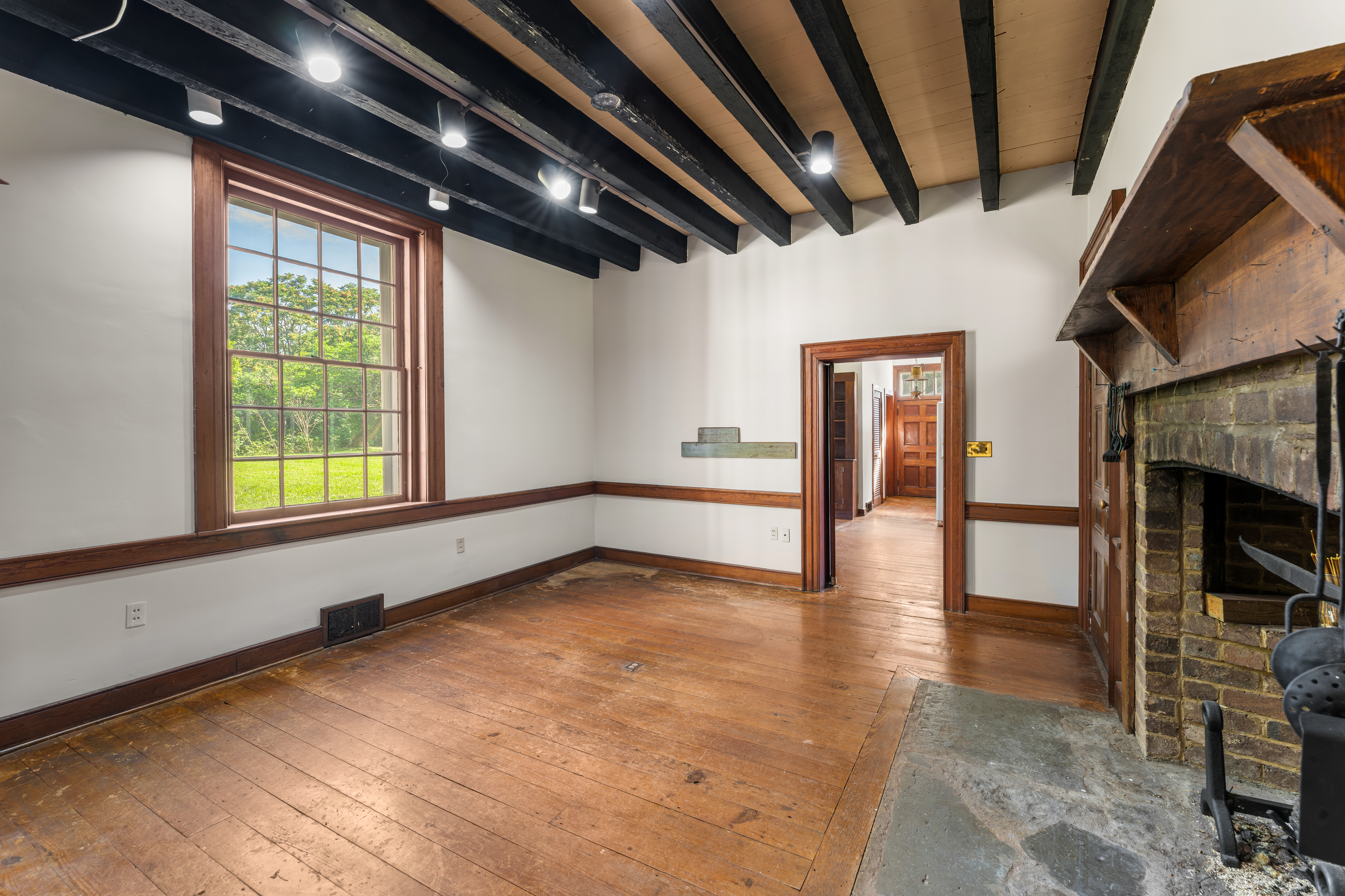 The keeping room — hand-hewn beams and cooking hearth