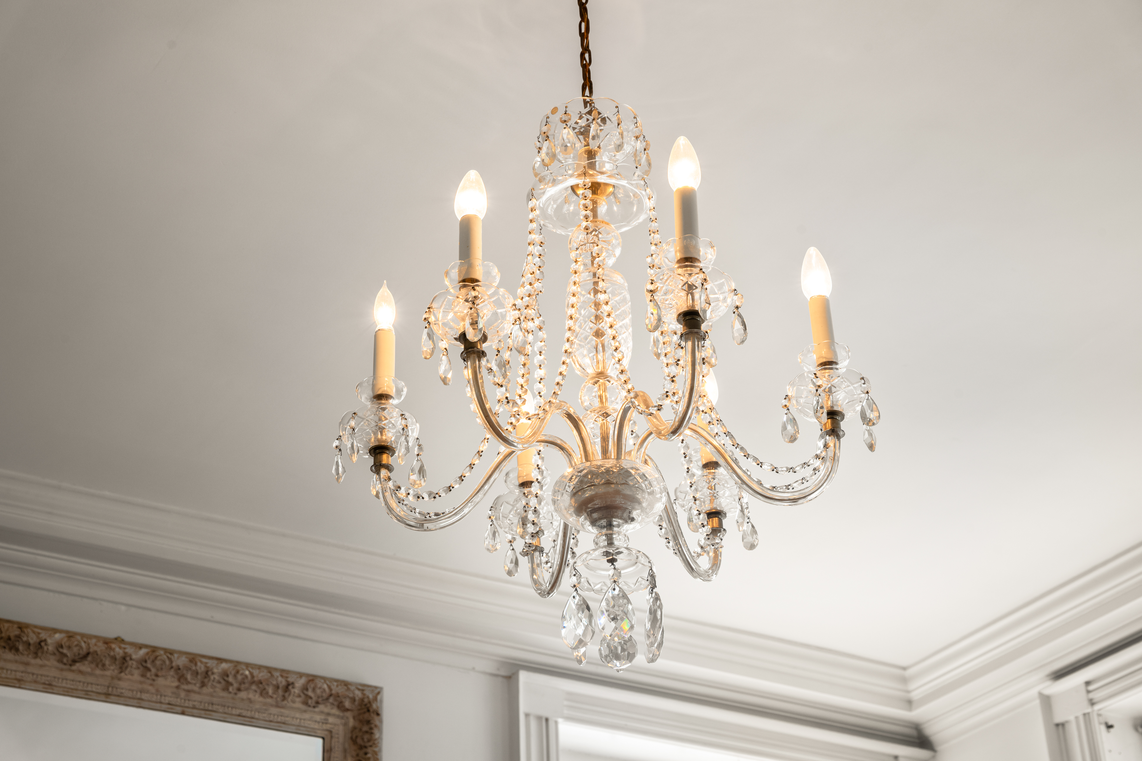 The drawing room chandelier above wide-plank floors