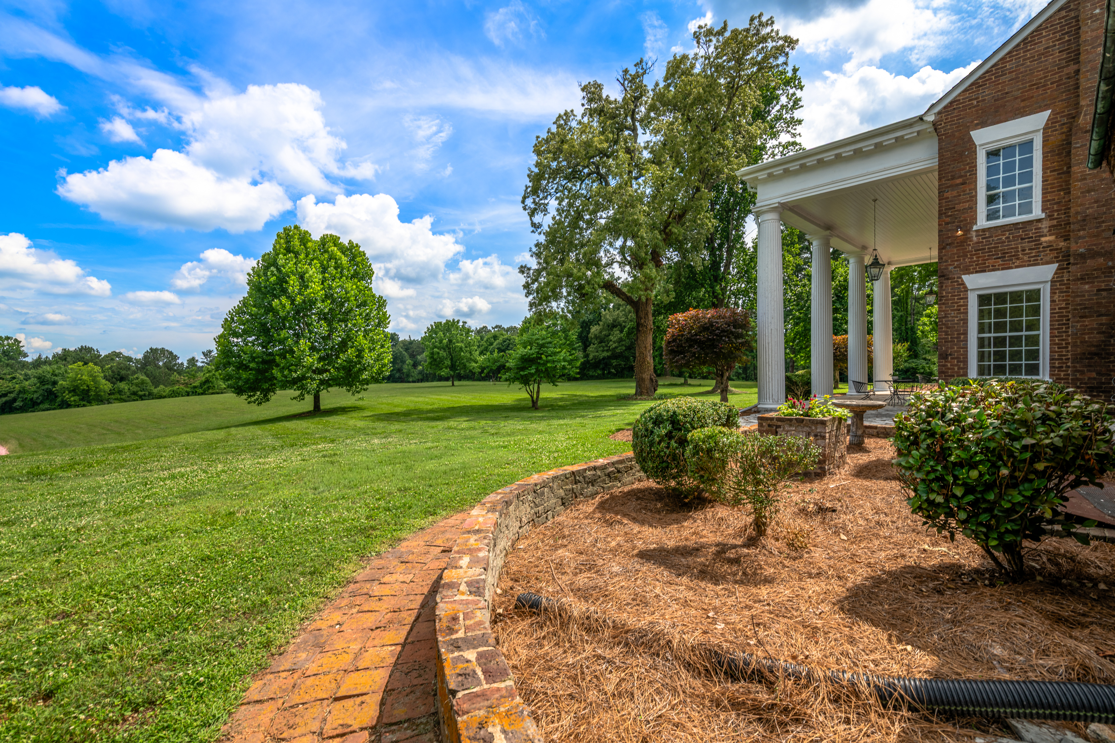 The side elevation with full porch and open lawn