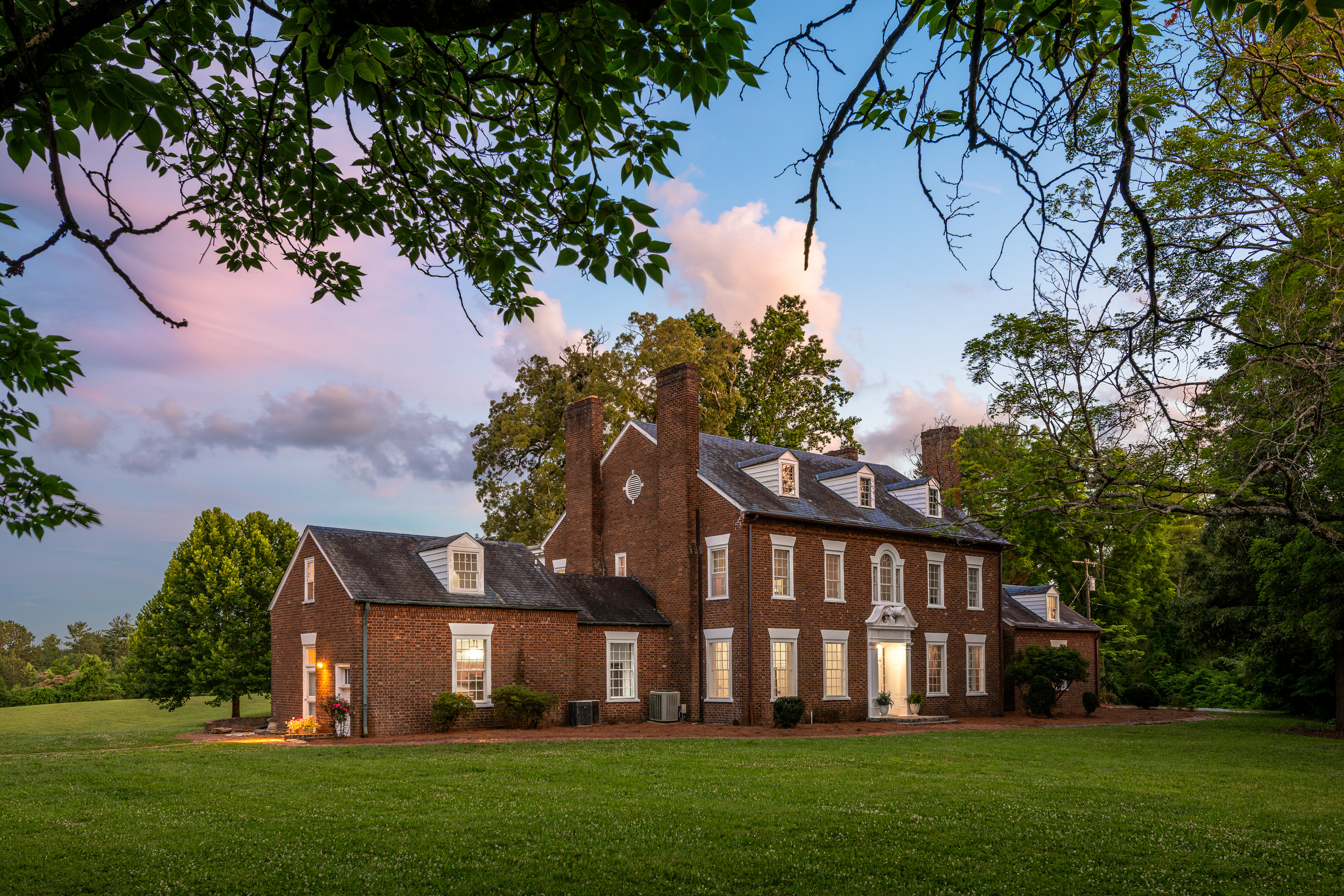 The manor at dusk beneath a rose sky