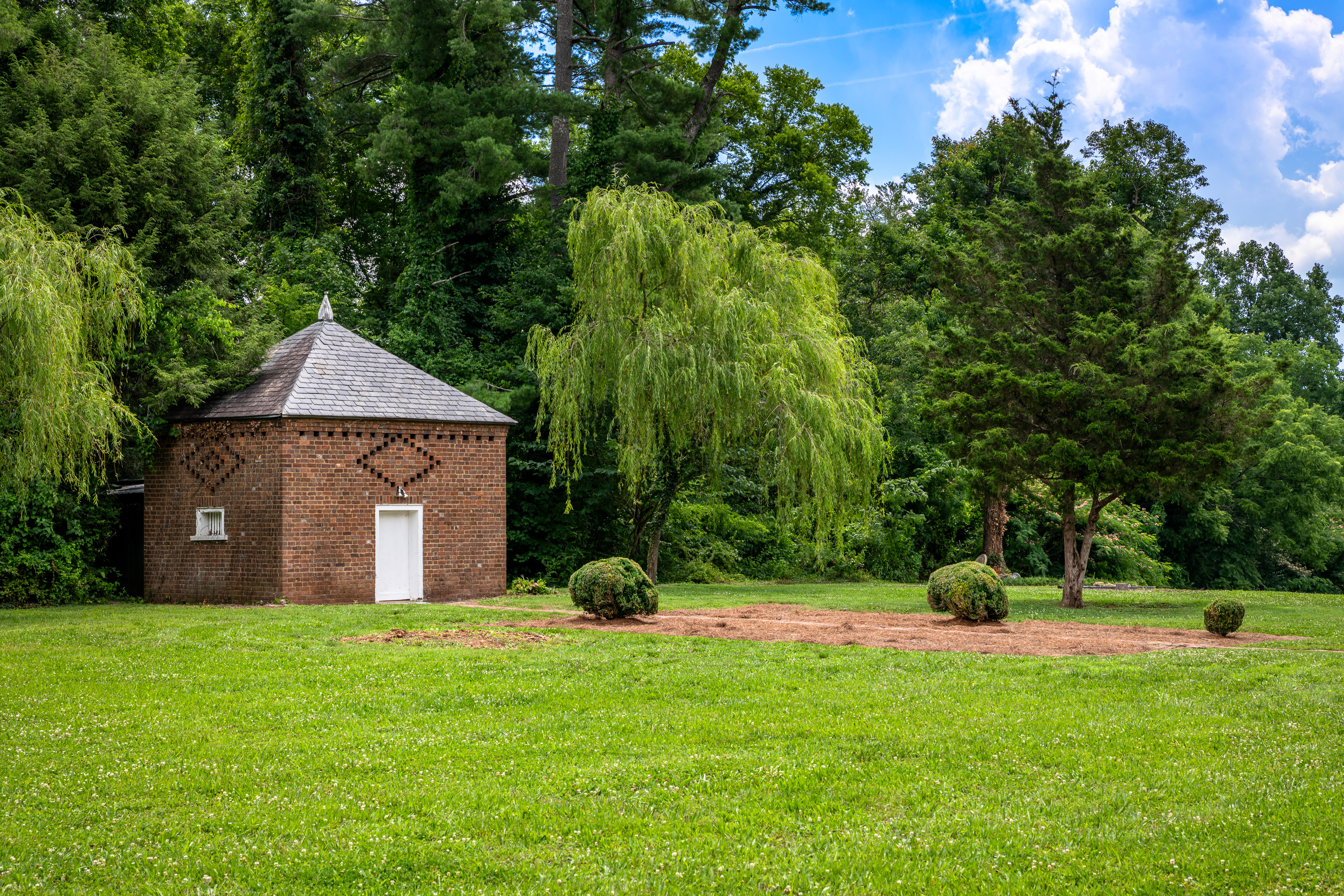 The smoke house among cedars and willows