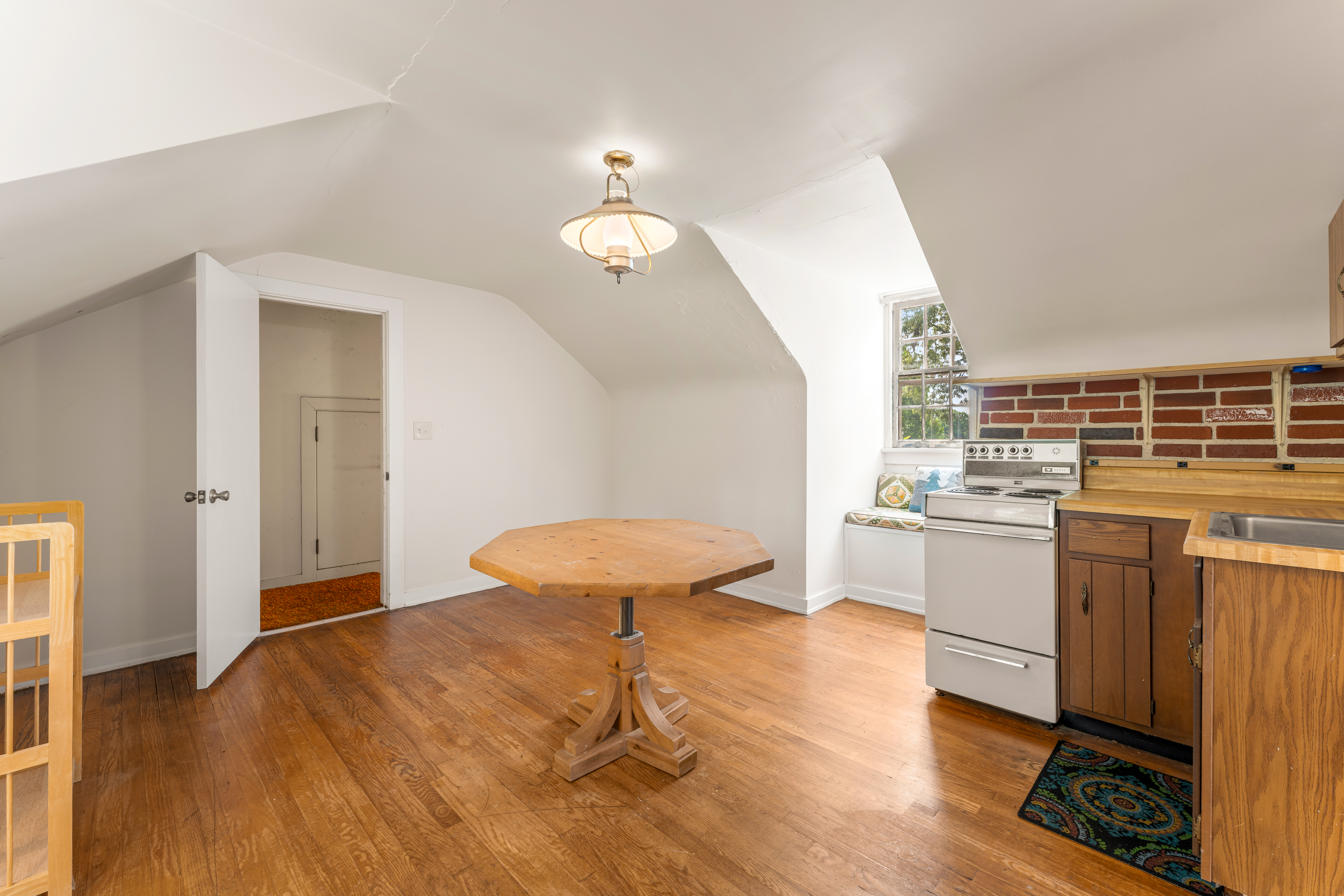 The apartment living area with dormer light and kitchen beyond