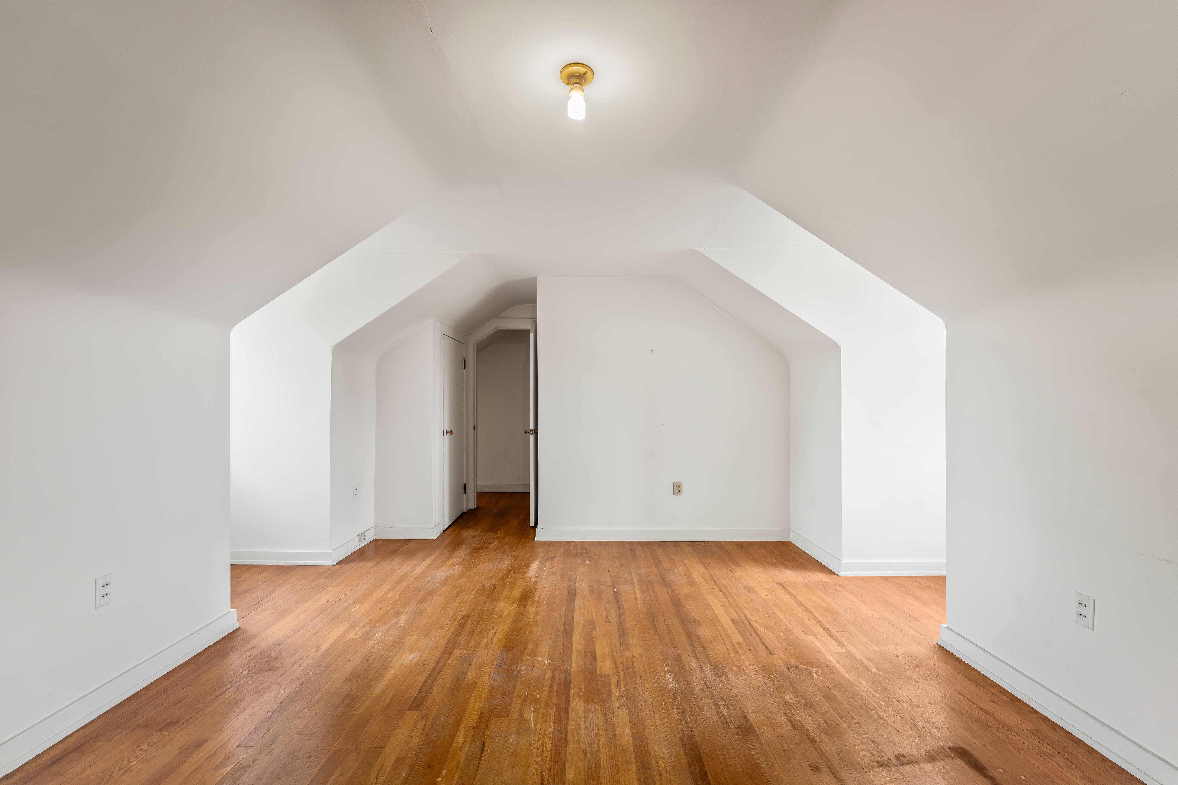 An upper room beneath the gable, wide-plank floors