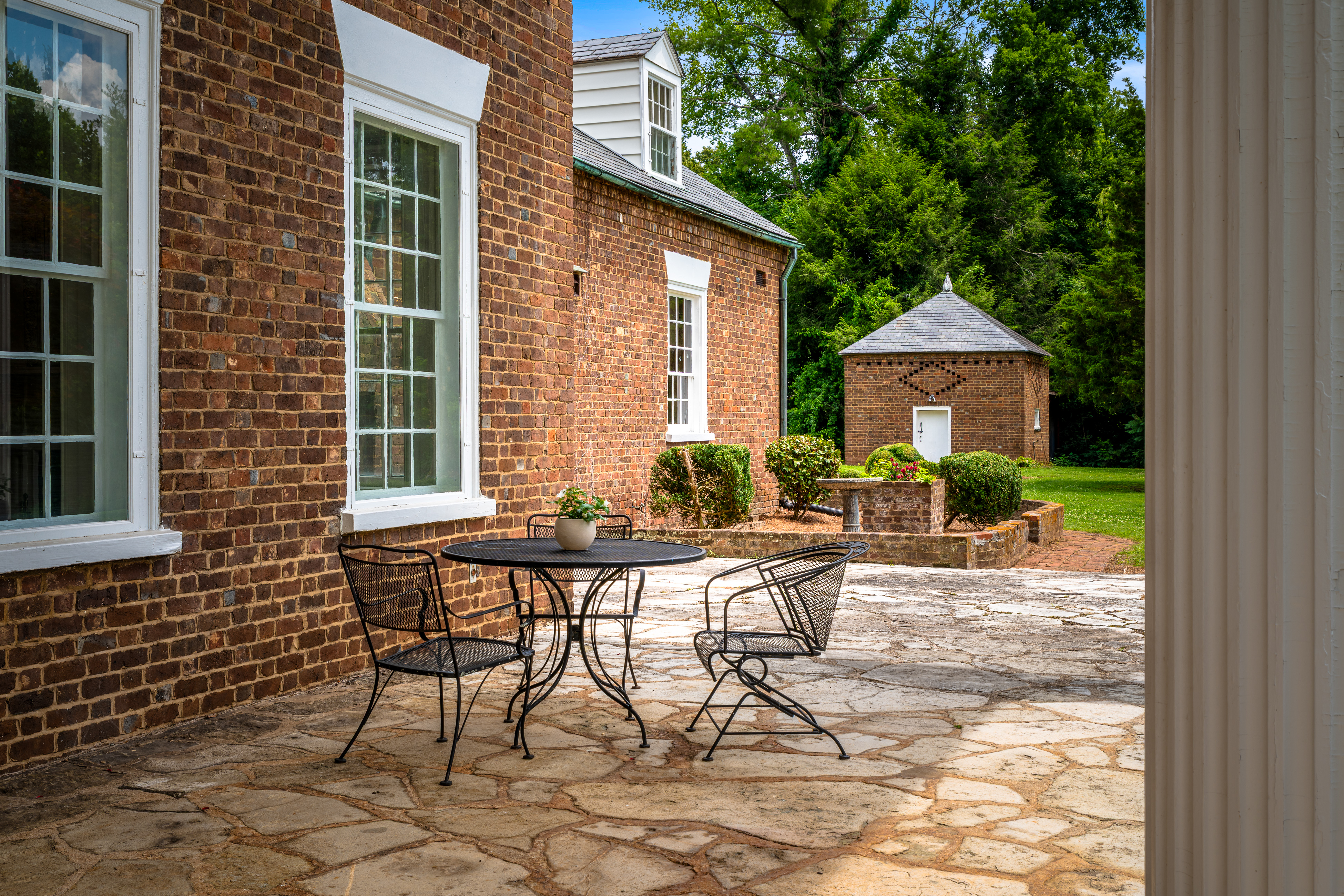 The side terrace with iron seating beside the porch