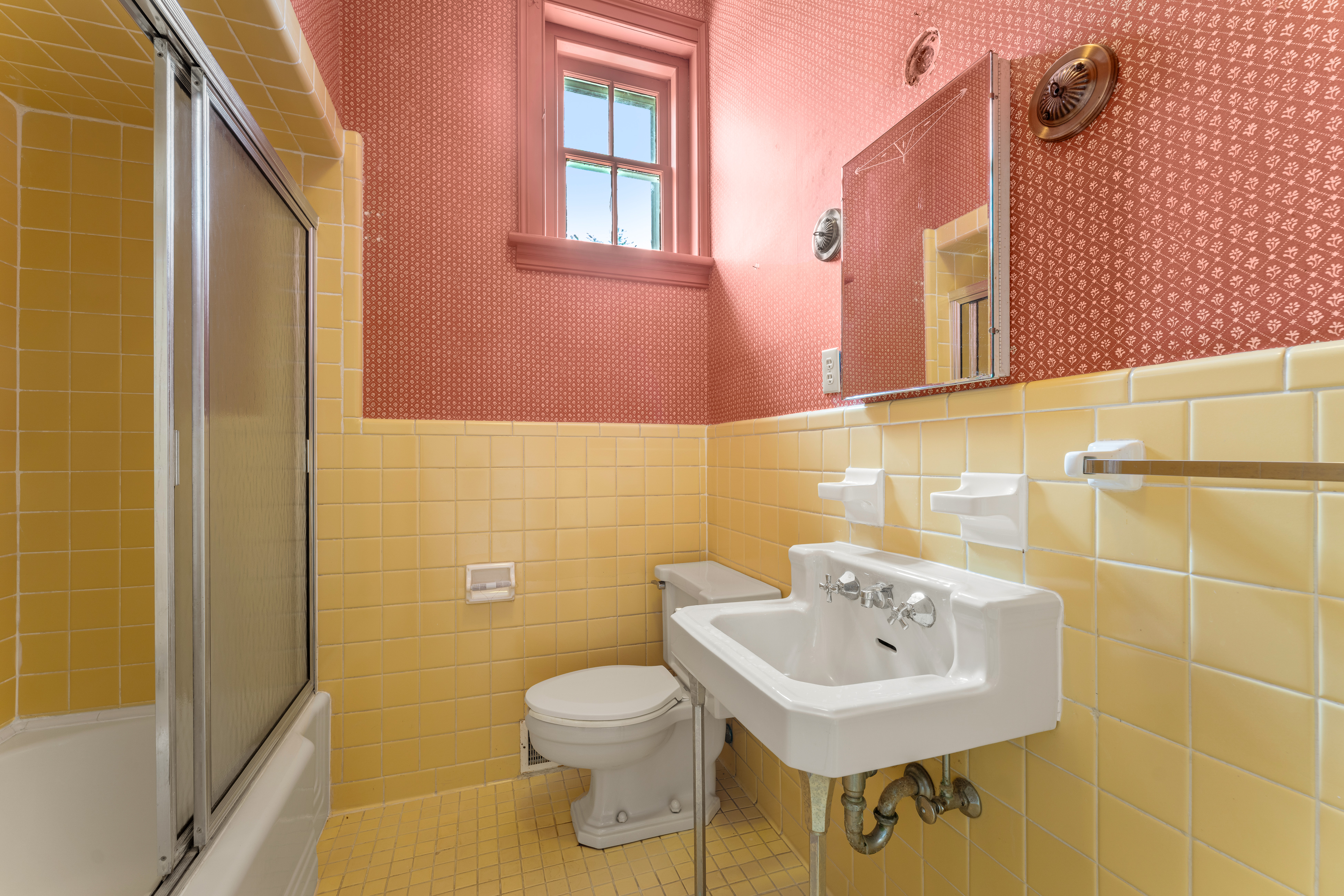 A mid-century en-suite in buttercup tile and rose plaster