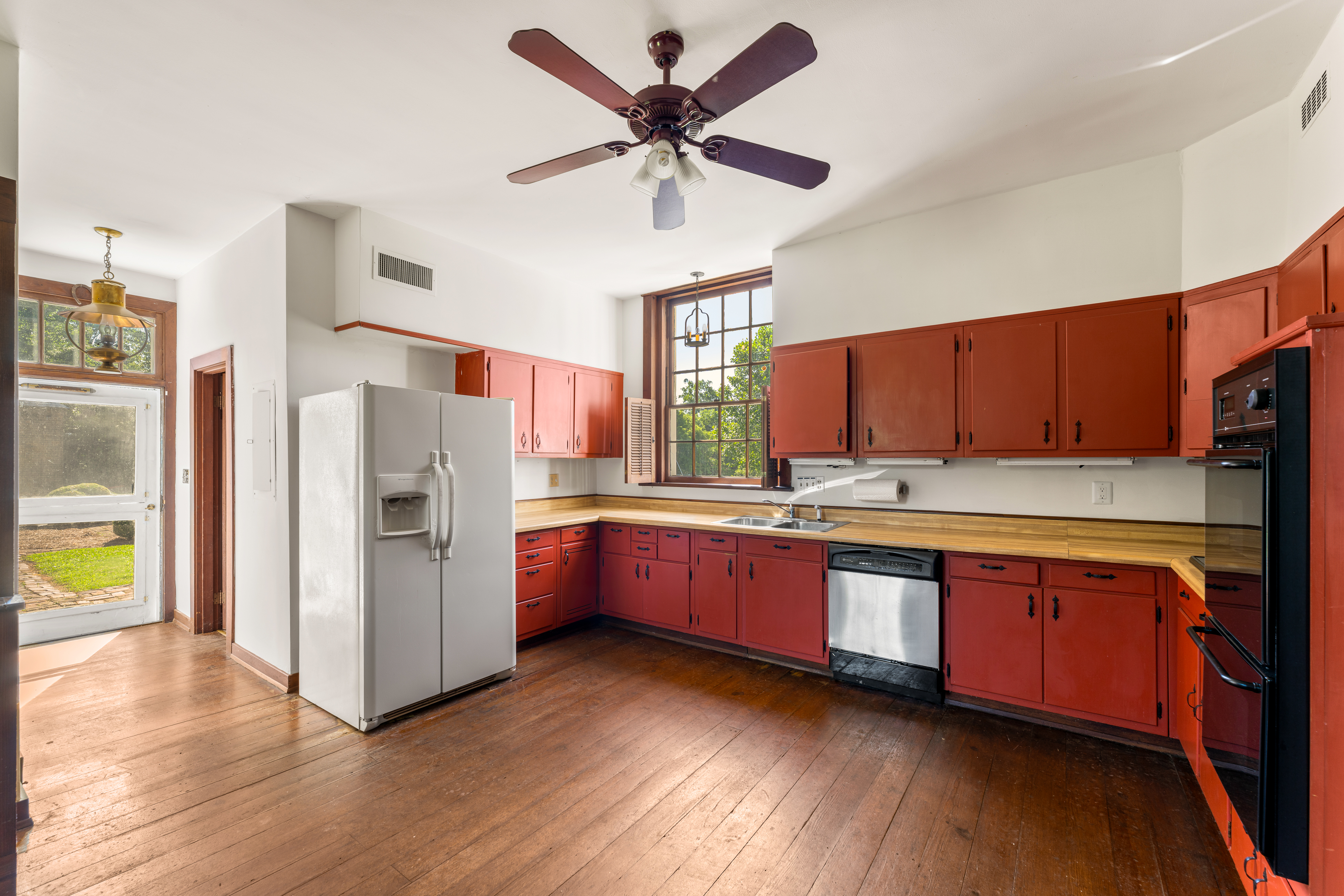 The kitchen — vermilion cabinetry and butcher-block counters