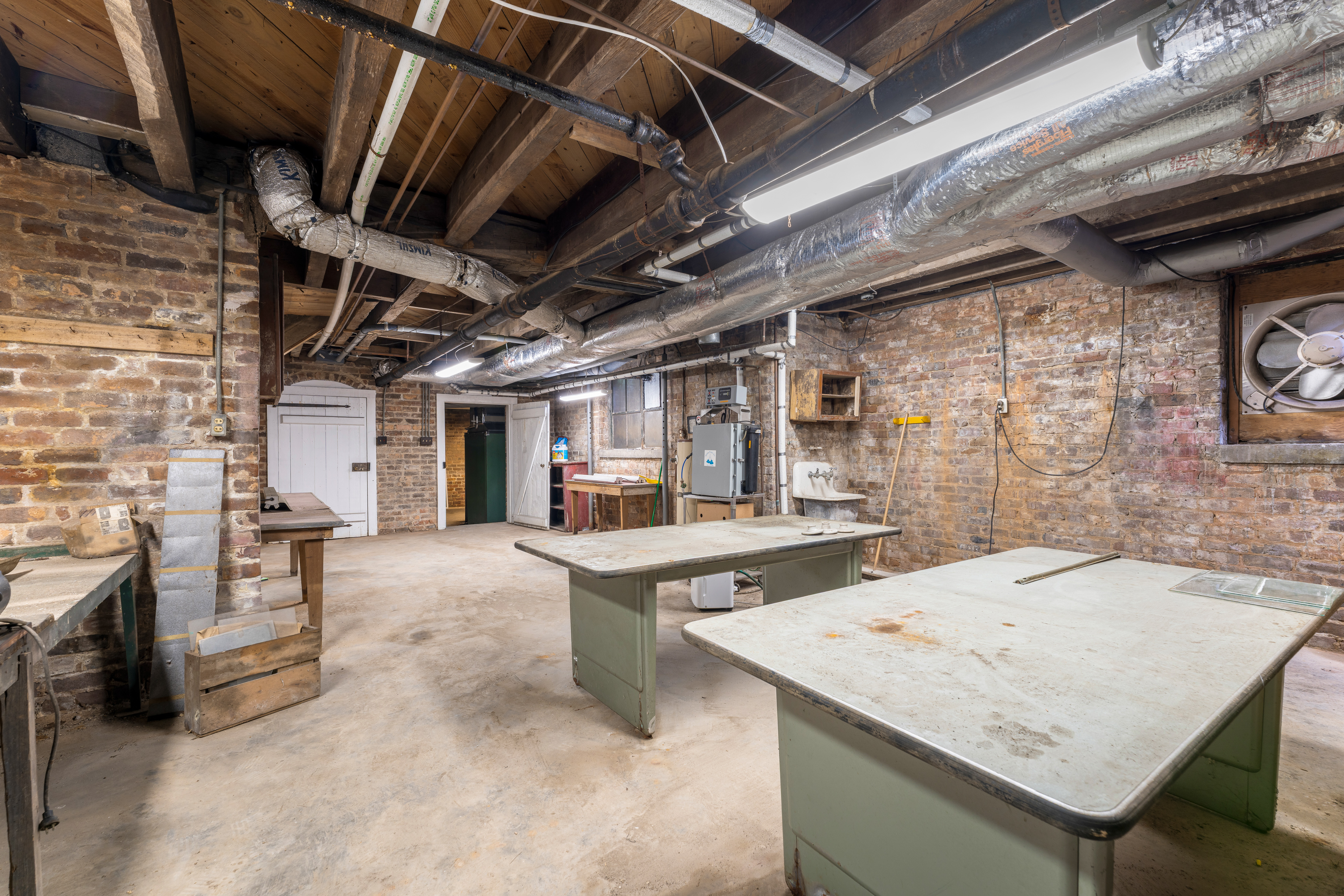 The lower level — original brick walls and hewn joists