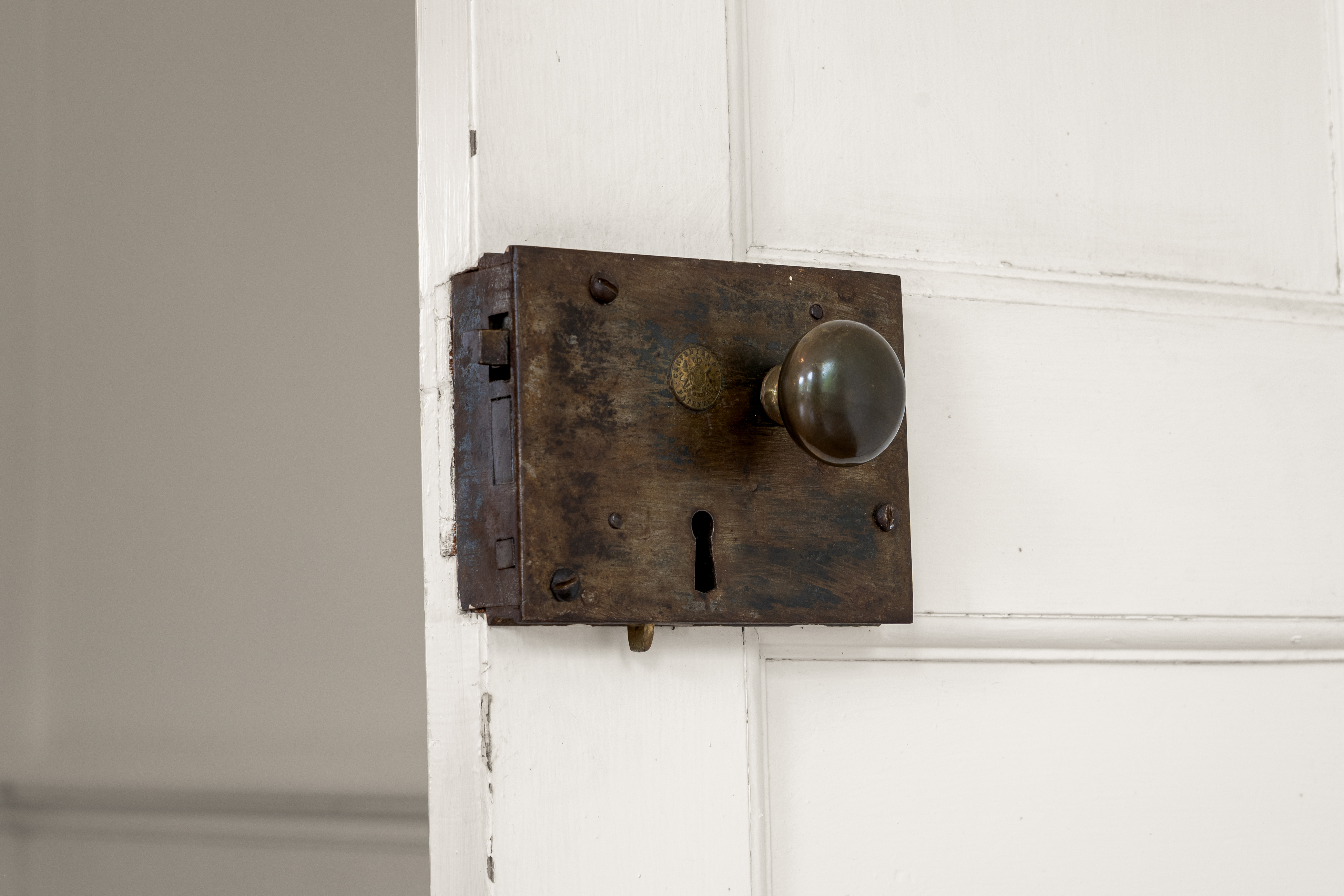 Original iron lock and brass keeper on a paneled door